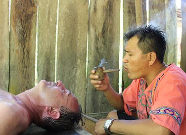 Shipibo Curandero don Ronor uses mapacho to protect a patient during an ayahuasca retreat